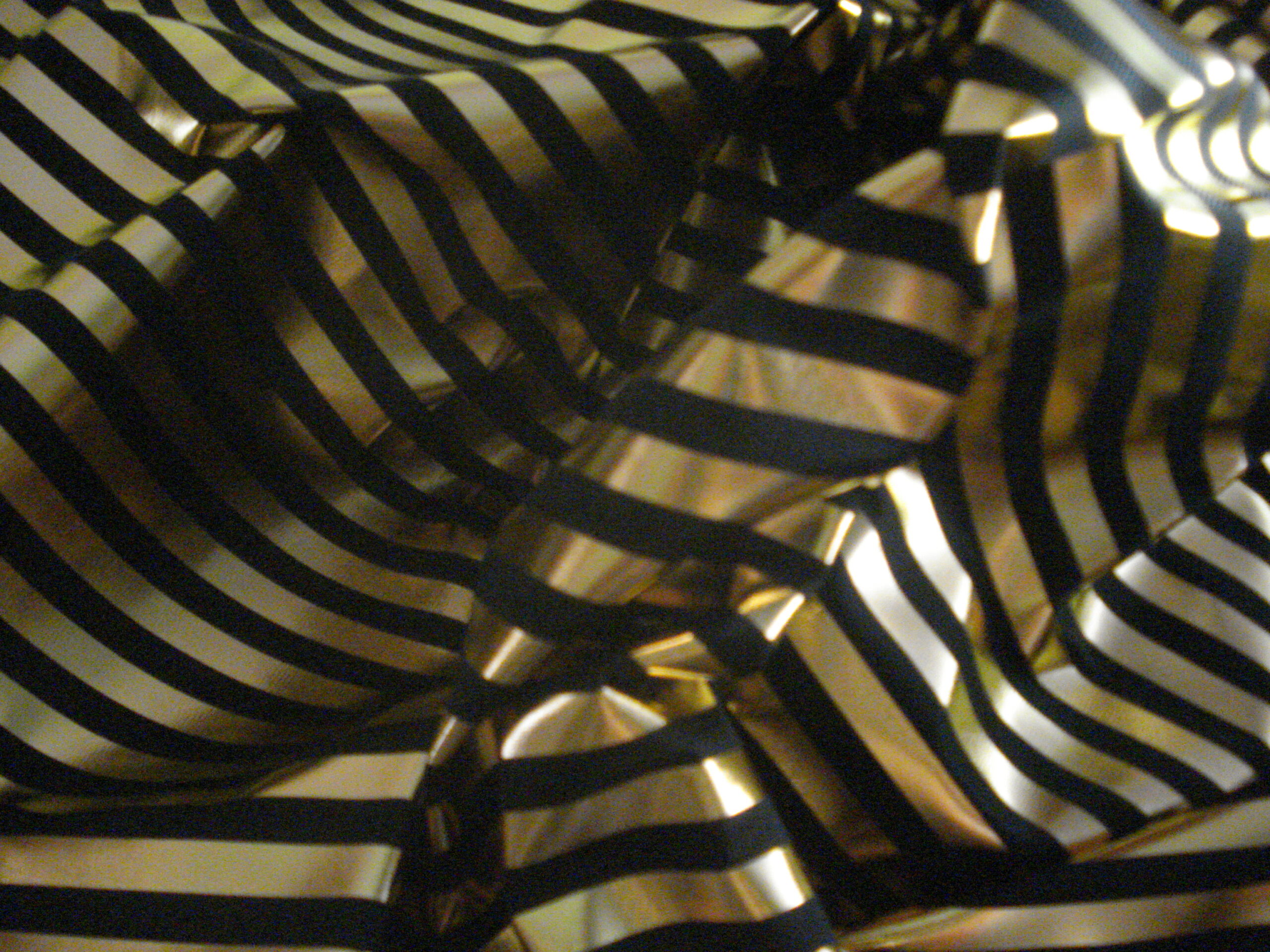 Tejido tipo gasa c/negro c/tiras de lamé doradas