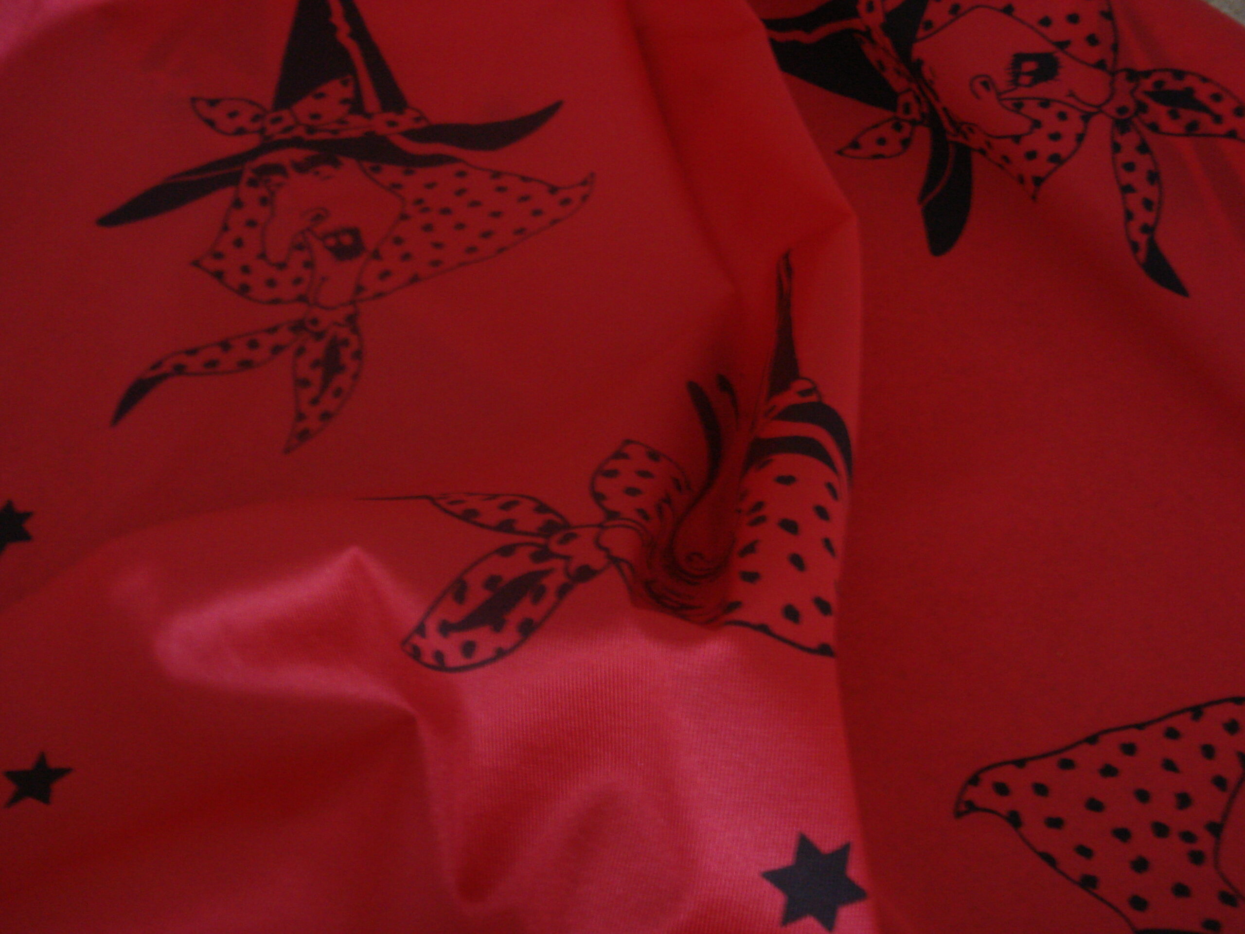 Tejido en rasete f/rojo dibujo caras bruja