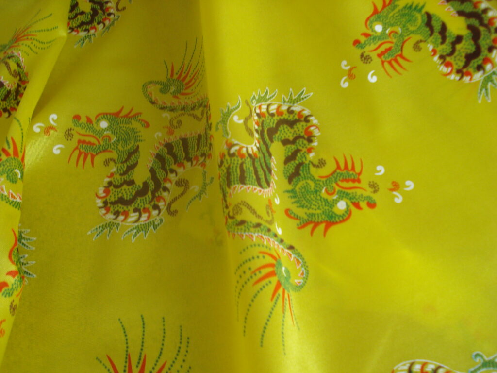 Tejido en rasete f/amarillo, dibujos dragones