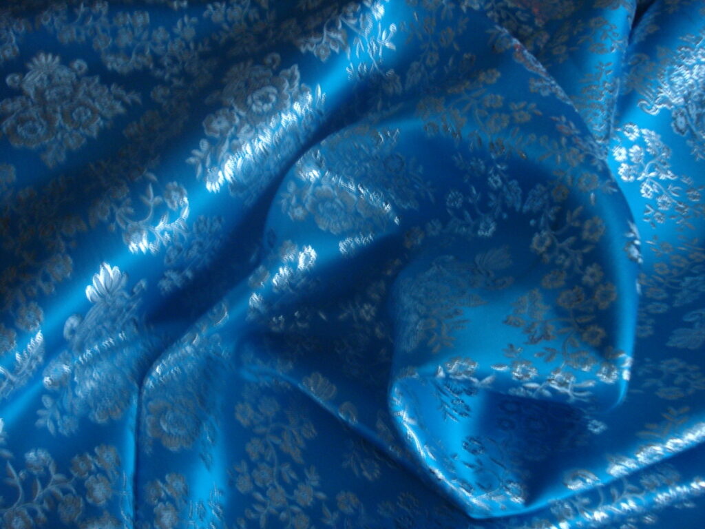 Tejido en raso f/azul cielo dibujo en plata