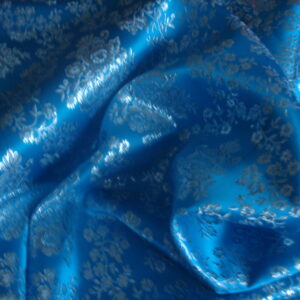Tejido en raso f/azul cielo dibujo en plata
