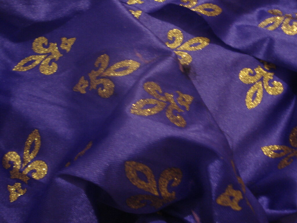 Tejido en rasete f/morado con estampado arabesco dorado purpurina