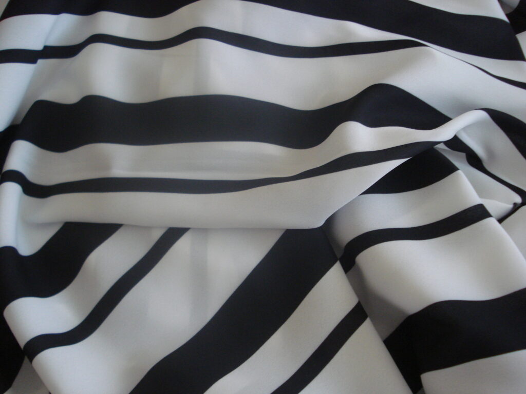 Tejido georgette en poliéster f/blanco y rayas negras gruesas y finas