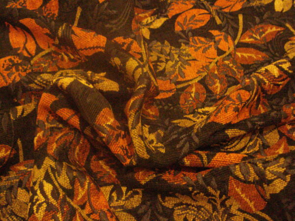 Tejido tipo "tapicería" c/fondo negro hojas marrones-verdes, ancho 1.44mts.