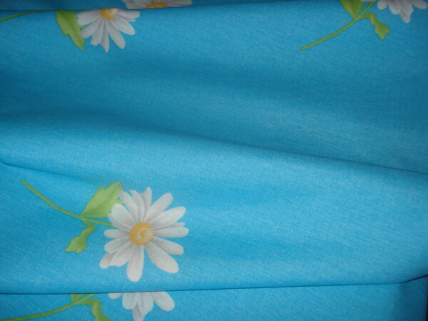 Tejido loneta f/azul claro c/dibujos margaritas, ancho 2,82mts.