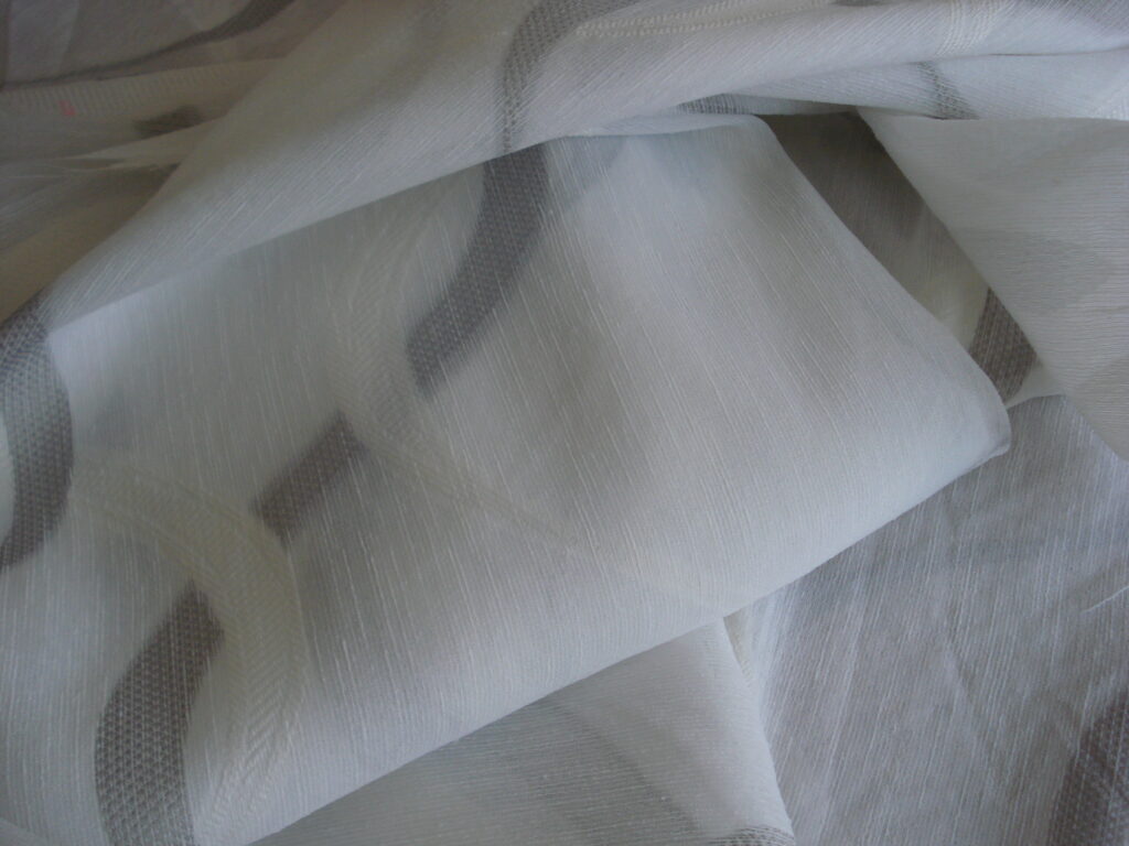 1 mto. tejido visillo fondo blanco dibujo geométrico blanco roto/gris, ancho 2,95mts.