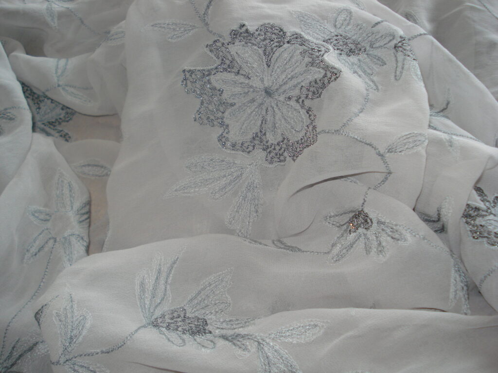 Tejido crepe georgette f/gris bordado flores grises c/hilo de lurex, ancho 1,42mts.