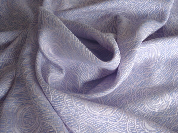 1,40mts. tejido twed color malva c/flores en relieve, ancho 1,50mts.