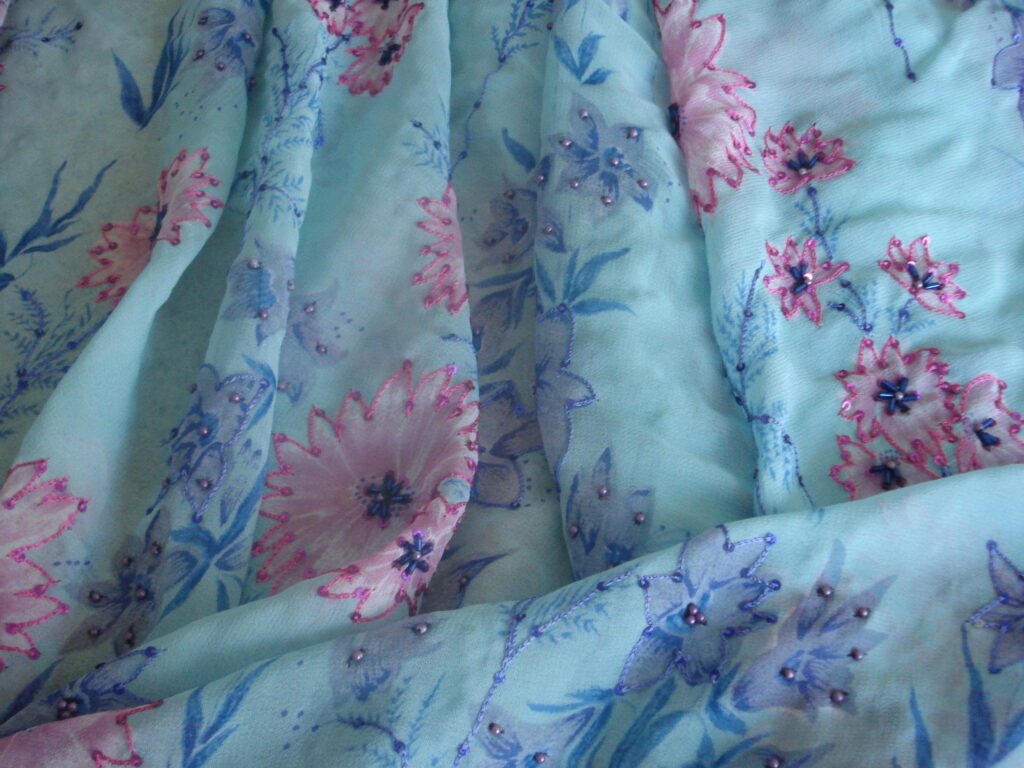 Tejido gasa f/azul estampado flores bordado y lentejuelas, ancho 1,15mts.