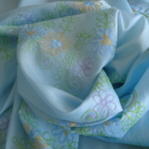 Tejido satinado efecto arrugado f/azul c/flores bordadas, ancho 1,50mts.